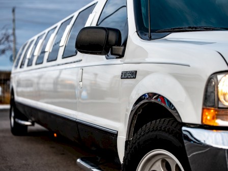 The image shows a white stretch limousine parked on a street.