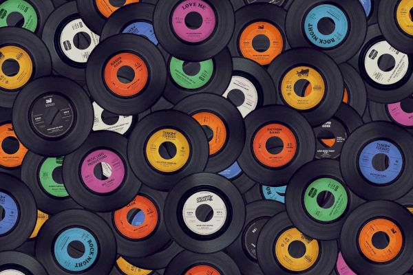 The image shows a collection of colorful vinyl records scattered and overlapping each other, showcasing various labels and designs.
