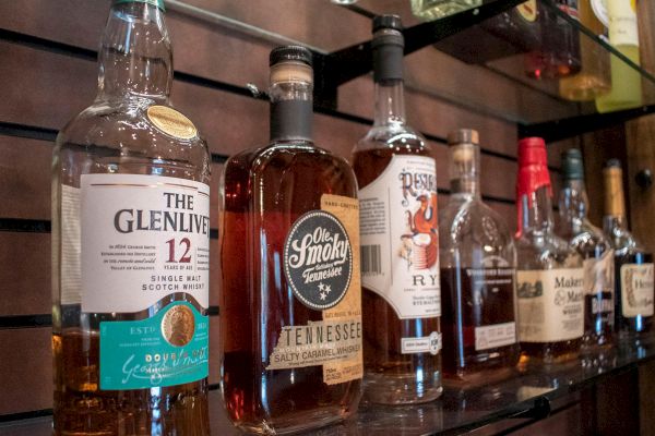 Several bottles of whiskey and other spirits are displayed on shelves, including brands like Glenlivet and Ole Smoky Tennessee Moonshine.