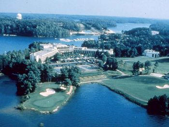 The image shows an aerial view of a lakeside resort complex with a golf course, numerous buildings, and surrounding forested areas, ending the sentence.