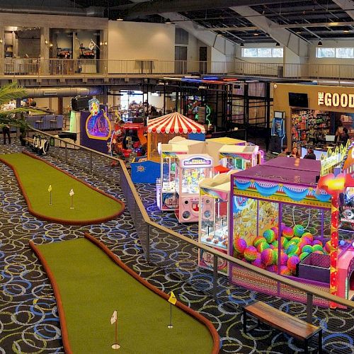 An indoor entertainment center with mini-golf, arcade games, claw machines, and a shop labeled 