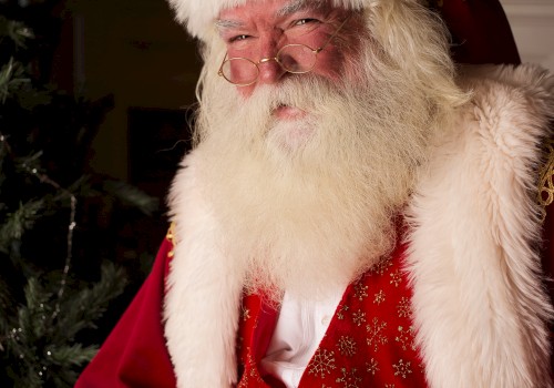 An individual dressed in a traditional Santa Claus costume, complete with a red suit, white fur trim, and a festive background.