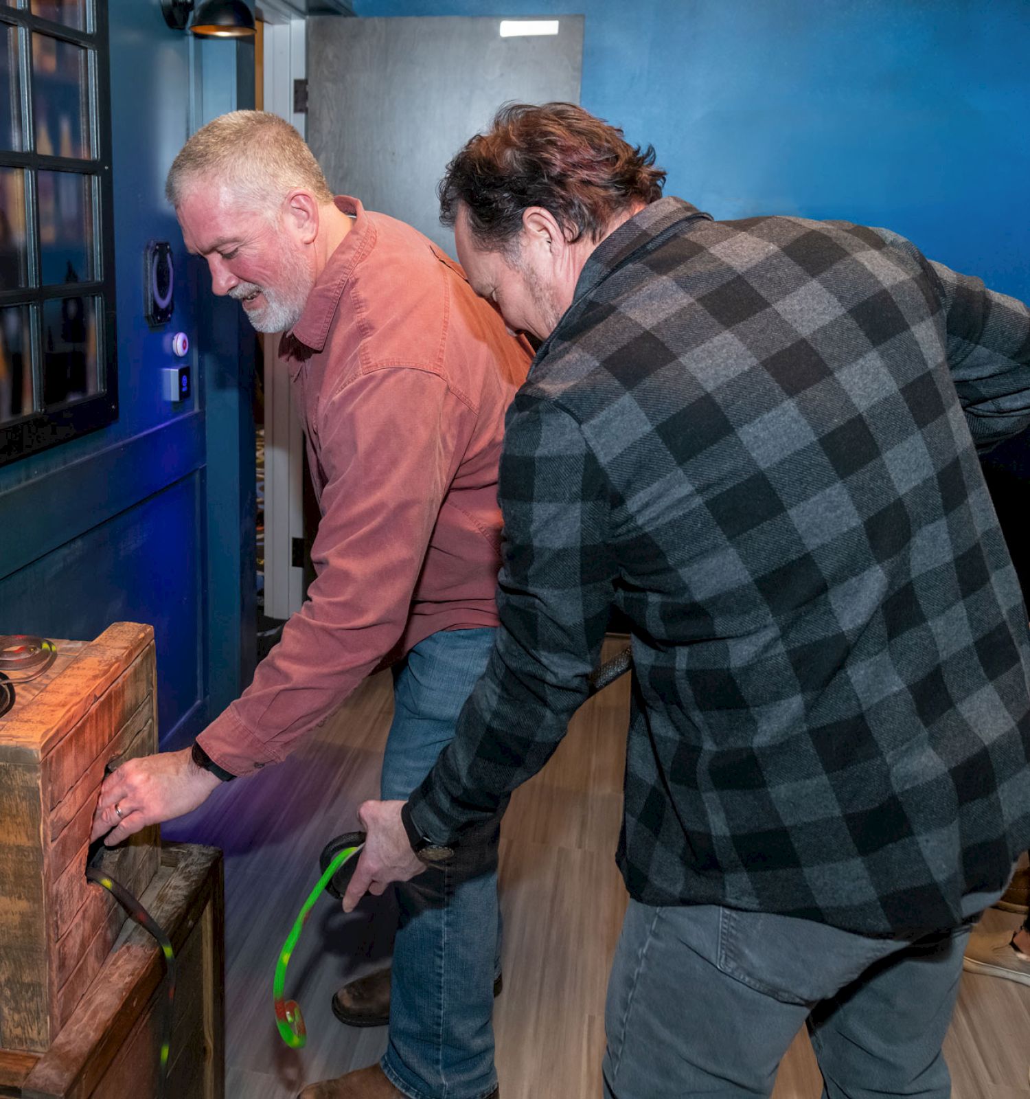 A group of people interact with a wooden box labeled 