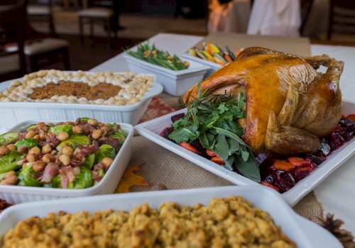 A table with a roasted turkey, stuffing, green beans, salad, and other dishes, likely for a festive meal, is shown in the image.