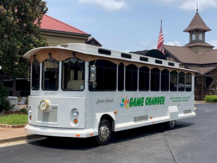 A white trolley-style vehicle labeled 